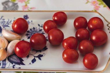 Bir masada sarımsak ile Kiraz domates