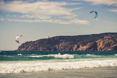 Guincho plaj denizi, sörfçülerin uçurtma uçurduğu arka planda mavi gökyüzü, Cascais, Portekiz