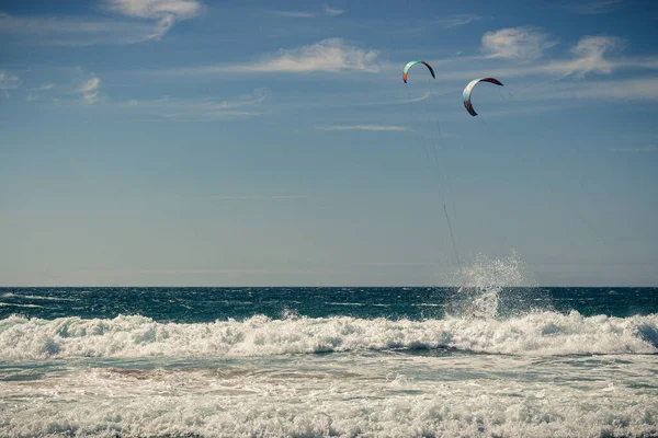 해변에는 파도타기를 사람들이 산딸나무를 다니고 뒤에는 하늘을 배경으로 포르투갈 카사스 — 스톡 사진