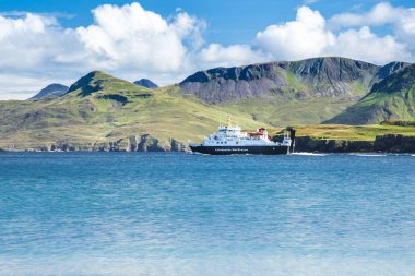 Arka planda yeşil dağlar ile denizde Calmac feribot - Caledonian Macbrayne feribot İskoçya, Dış Hebrides Highlands faaliyet