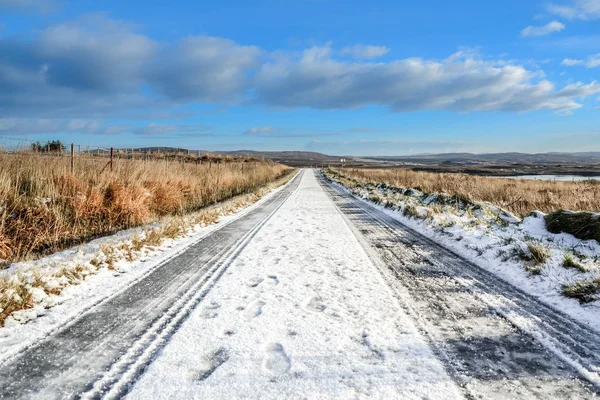 Snow covered road, icy road conditions, travelling through Scotland, Scottish winter landscape