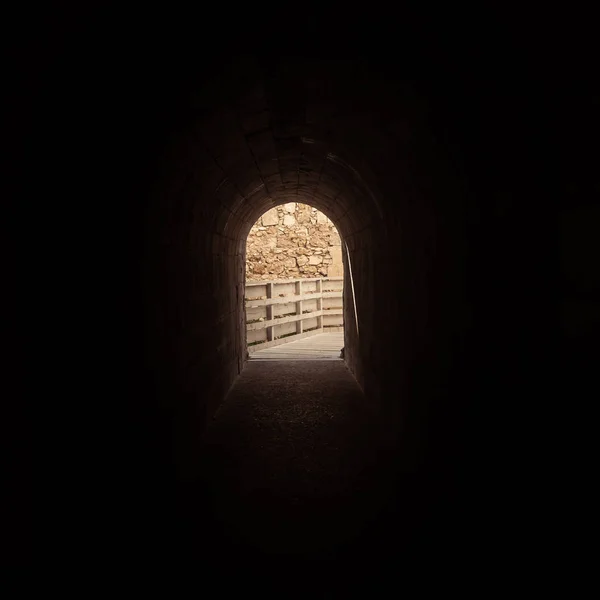 A light in the end of a tunnel. Medieval gate in the old castle.