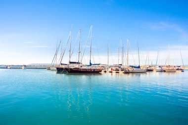 Ortigia, Syracuse, İtalya / Aralık 2018: Yelkenli ve yatlar demirledi yat limanında. Turkuaz deniz suyu, güneşli gökyüzü, Romantik İtalyan sahne