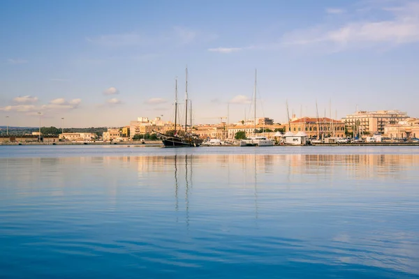 Ortigia, Syracuse, İtalya / Aralık 2018: Yelkenli ve yatlar demirledi yat limanında. Turkuaz deniz suyu, güneşli gökyüzü, Romantik İtalyan sahne