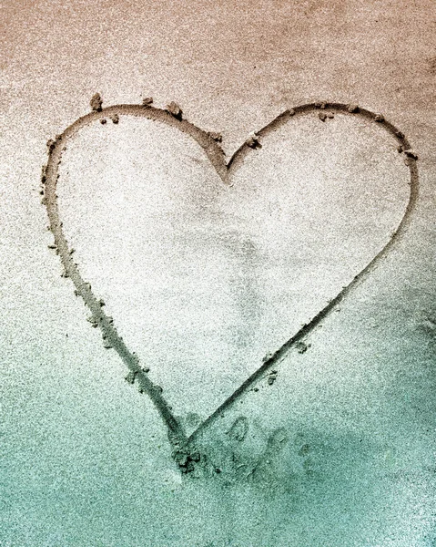 Sign of love heart shape on sand