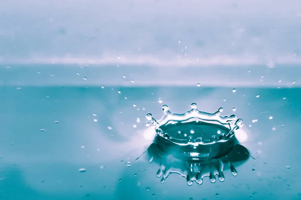 Wasserspritzer isoliert auf blauem Hintergrund — Stockfoto