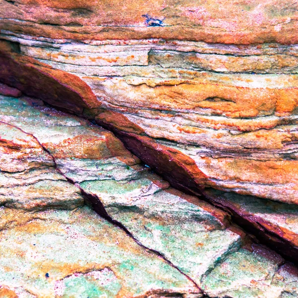 Multicolored rock wall from bottom sediments red orange dark ray — Stock Photo, Image