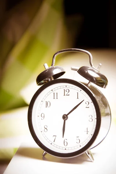 Relógio de alarme - relógio de alarme clássico vintage ao lado da cama no leito — Fotografia de Stock