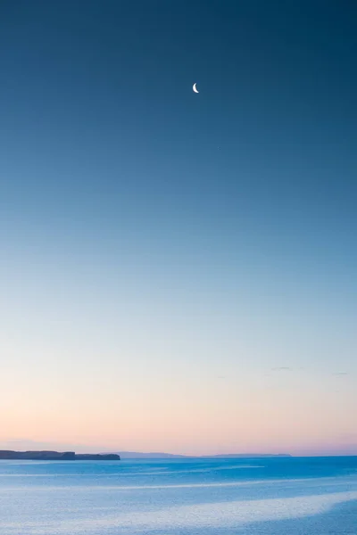 Luna sobre el Océano Atlántico con cielo púrpura y montañas en th — Foto de Stock