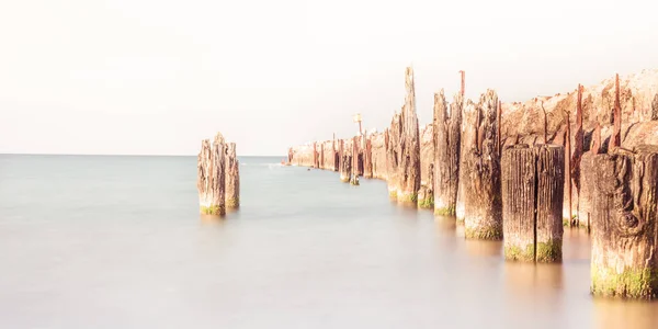 Quebra-mar de madeira em uma praia em Ustka, Polônia, Mar Báltico — Fotografia de Stock