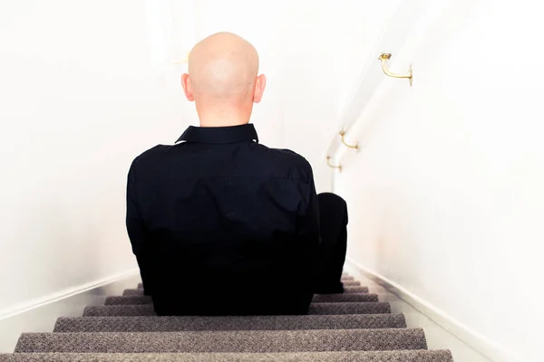 Young depressed man sitting on a floor and crying