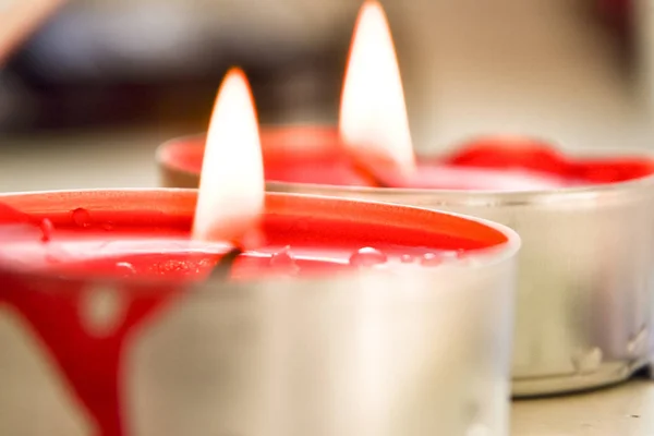 Nahaufnahme brennender roter Kerze auf Bokeh-Hintergrund — Stockfoto