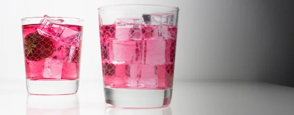 Свежие ягоды и водка в стакане на белом фоне — стоковое фото