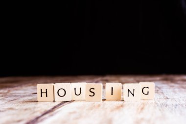 Koyu ahşap arka plan üzerinde fayans yapılmış Konut kelime 