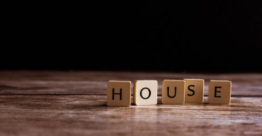 Koyu ahşap arka plan üzerinde fayans yapılmış House kelime 