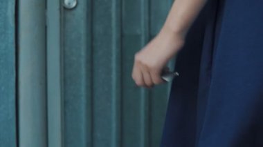 Kız büyük bir anahtarla kapıyı açar ve kapıdan içeri girer.