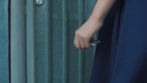 Flickan öppnar dörrlåset med en stor nyckel och går in genom dörren — Stockvideo