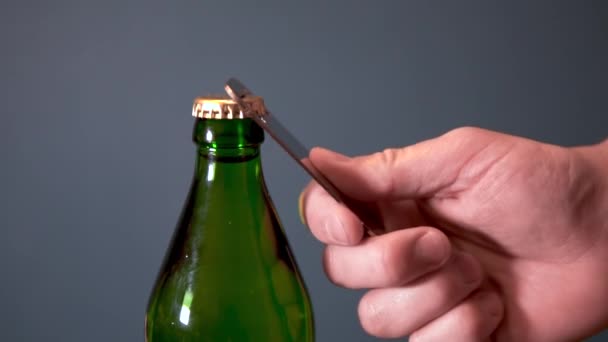 Homem abre garrafa com bebida gasosa com um abridor especial. Garrafa de vidro com tampa de metal — Vídeo de Stock
