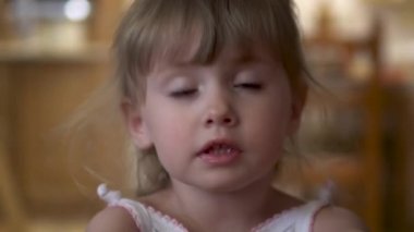 Küçük kız kameraya yakından bakıyor.