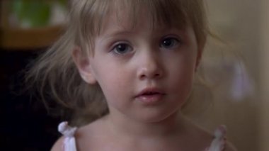 Küçük kız kameraya yakından bakıyor.