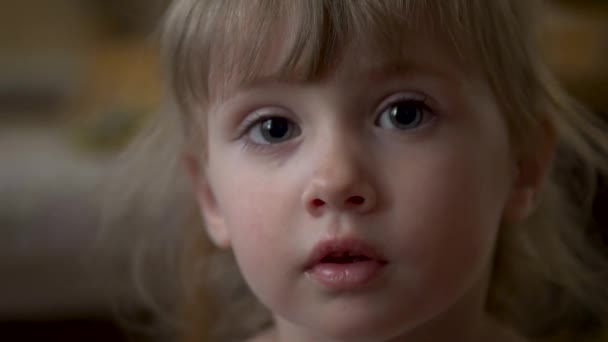 Маленькая девочка смотрит в камеру крупным планом — стоковое видео