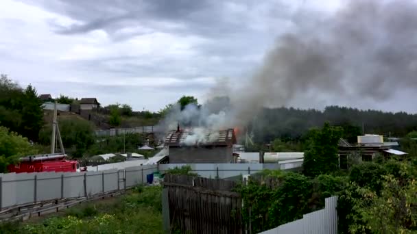 Los bomberos extinguen el fuego doméstico. Fuego en la cabaña — Vídeo de stock