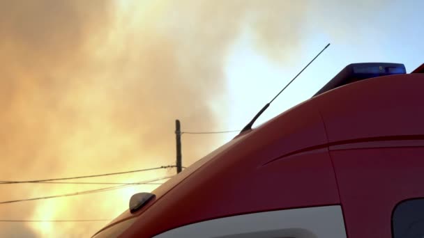 Brandweerauto met knipperende lichten op een achtergrond van rook uit een brand — Stockvideo