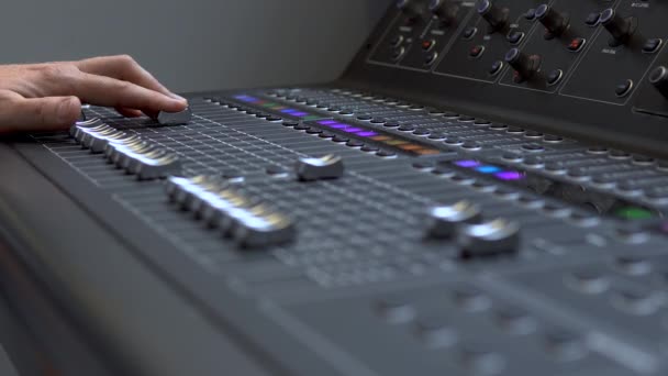 O homem trabalha em um mixer de áudio eletrônico profissional. Um painel de controle para sintonizar canais de som — Vídeo de Stock