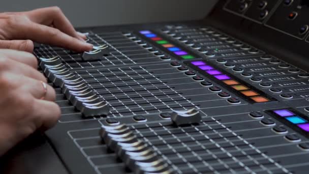 Man travaille sur un mixeur audio électronique professionnel. Un panneau de commande pour régler les canaux sonores — Video