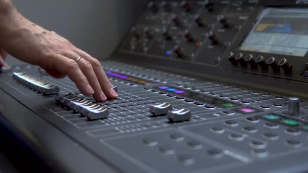 L'uomo lavora su un mixer audio elettronico professionale. Un pannello di controllo per sintonizzare i canali sonori — Video Stock