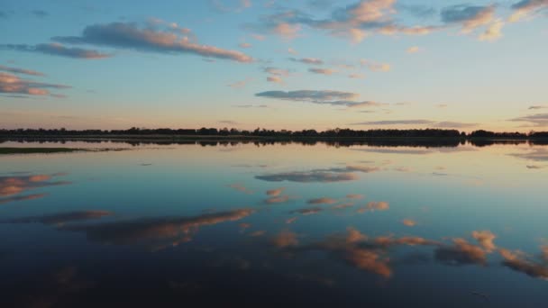 Panorama van het meer bij zonsondergang. Het meer weerspiegelt de lucht — Stockvideo