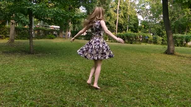 Дівчина крутиться на траві — стокове відео