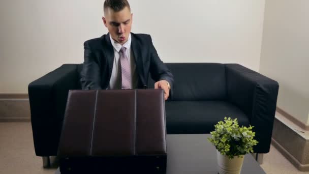Бизнесмен лежит на диване и читает документы — стоковое видео