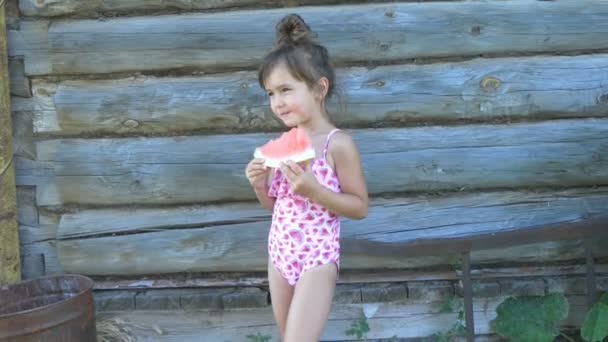Το κορίτσι τρώει καρπούζι με μαγιό. — Αρχείο Βίντεο