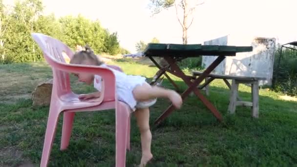 Climbs on a chair a little girl — Stock Video