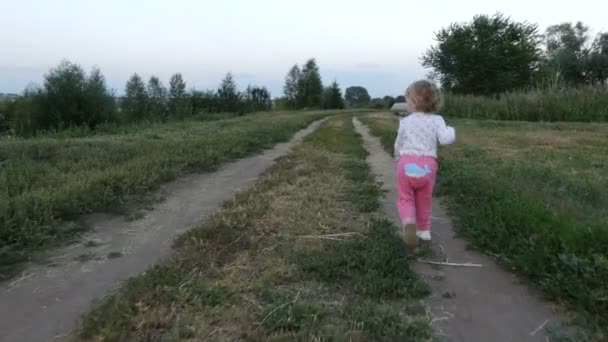 Küçük kız yol boyunca koşuyor. — Stok video