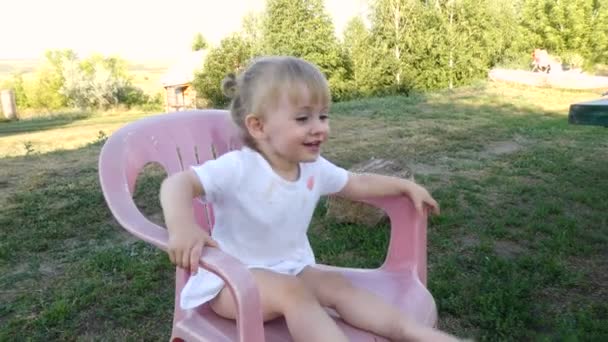 Kislány mászik le a székről — Stock videók