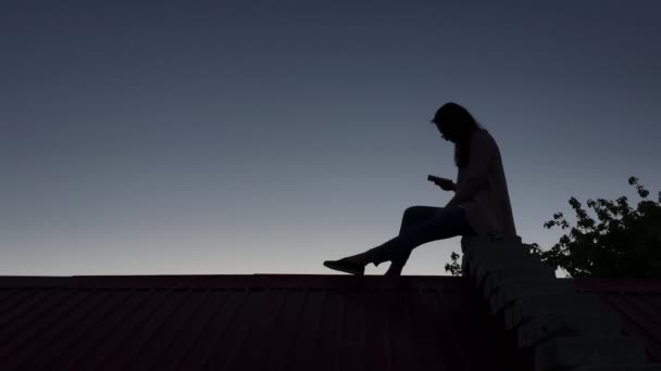 Dívka sedí na střeše — Stock video