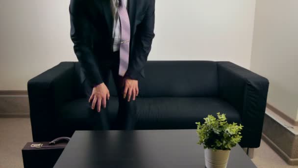 Hombre de negocios esperando una reunión en el sofá — Vídeos de Stock