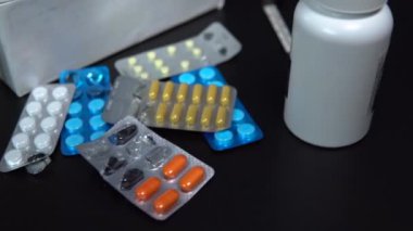 İlaçlar masanın üstünde. Hastalığın tedavisi için farklı renkli haplar masada yatıyor.