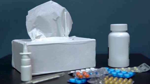 Μια γυναίκα παίρνει μια χαρτοπετσέτα. Φάρμακα στο τραπέζι. Πολύχρωμα χάπια για τη θεραπεία των ασθενειών βρίσκονται στο τραπέζι — Αρχείο Βίντεο