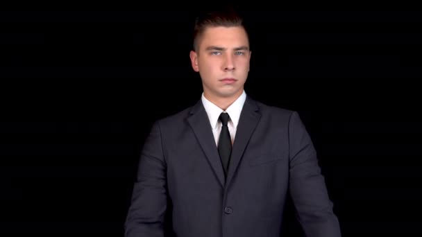 Young businessman shows his hands a cross and shakes his head denying. Man in a black suit on a black background — Stock Video