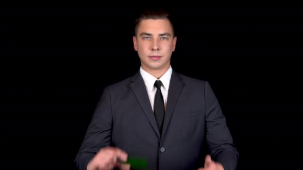 Joven hombre de negocios presenta una tarjeta verde de banco y muestra como con su mano. Tarjeta verde Chromakey. Hombre con traje negro — Vídeos de Stock