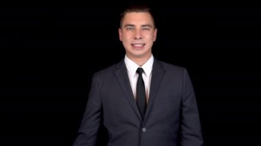 Genç bir iş adamı yeşil bir banka kartı sunar. Kromakey yeşil kart. Siyah arka planda siyah takım elbiseli adam.