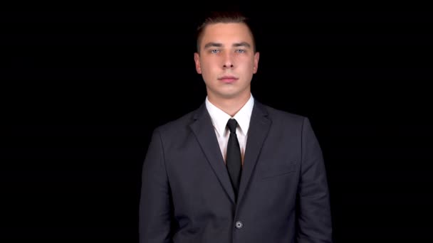 Young businessman shakes his head denying. Man in a black suit on a black background — Stock Video