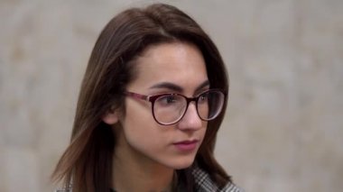 Metroda genç bir kadın duruyor. Arka planda bir tren gidiyor. Yakın plan kız yüzü.