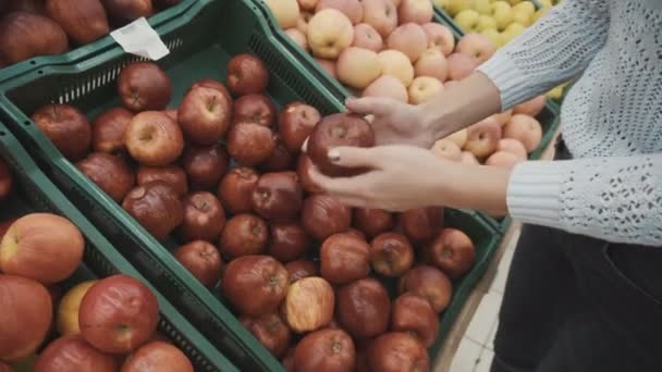 Het meisje plukt appels op de markt — Stockvideo