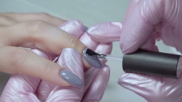 Маникюрша красит ногти девушки — стоковое видео