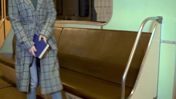 Une jeune femme lit un livre dans un métro. Ancienne voiture de métro — Video