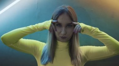 Neon klapaların arkasında dans eden modaya uygun bir kız.